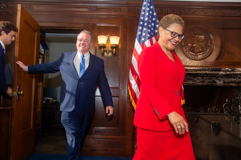 Los Angeles, CA - October 04: Jim McDonnell (L) and Mayor Karen Bass arrive at a press conference to introduce the new Chief LAPD at City Hall Friday, Oct. 4, 2024 in Los Angeles, CA. (Ringo Chiu / For The Times)