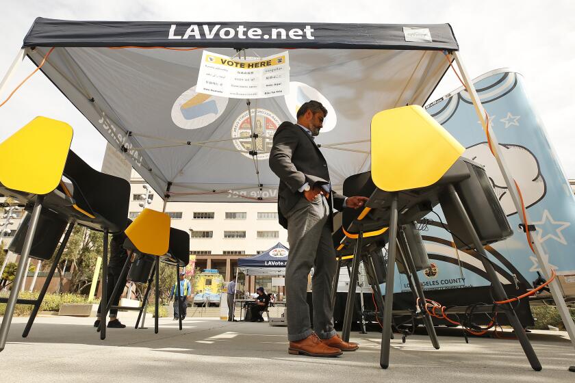 LOS ANGELES, CA - FEBRUARY 27, 2020 Francisco "Franky" Carrillo cast his votes at the Mobile Vote Center assembled in Grand Park as the Los Angeles County Registrar-Recorder/County Clerk is trying to provide voters who live and work in downtown with the opportunity to vote in-person in the 12-acre park through 6 p.m. on Thursday. This is part of the county's transition from polling places to vote centers as residents are able to vote at any vote center and are no longer assigned to a specific polling location for in-person voting. (Al Seib / Los Angeles Times)