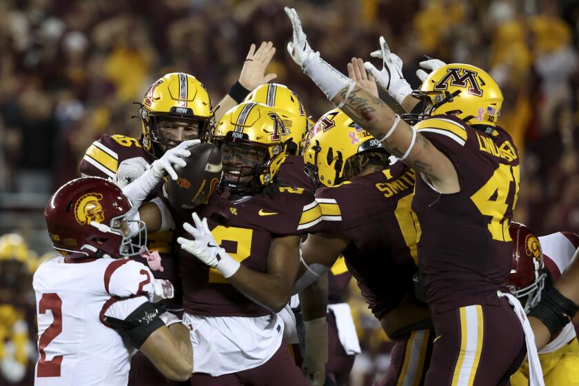 Minnesota defensive back Ethan Robinson is surrounded by teammates as he celebrates recovering a USC fumble