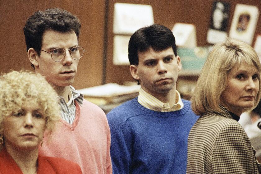 Lyle Menendez, right, and brother Erik listen to a charge of murder conspiracy against them with Leslie Abramson, far left, attorney for Erik, Dec. 29, 1992 in Los Angeles. The brothers pled innocent to the new indictment which dropped the original charge that they killed their parents for money. The indictment was returned nearly three years after Joseph and Kitty Menendez were found slain in their home. (AP Photo/Chris Martinez)