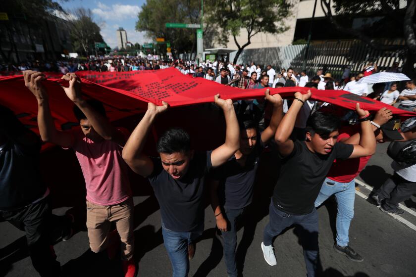 Demonstrators march in remembrance of the 1968 Tlatelolco student massacre, an event considered part of the Mexico's "dirty war" when the government used its forces to suppress political opposition in Mexico City, Oct. 2, 2019. (AP Photo/Fernando Llano)