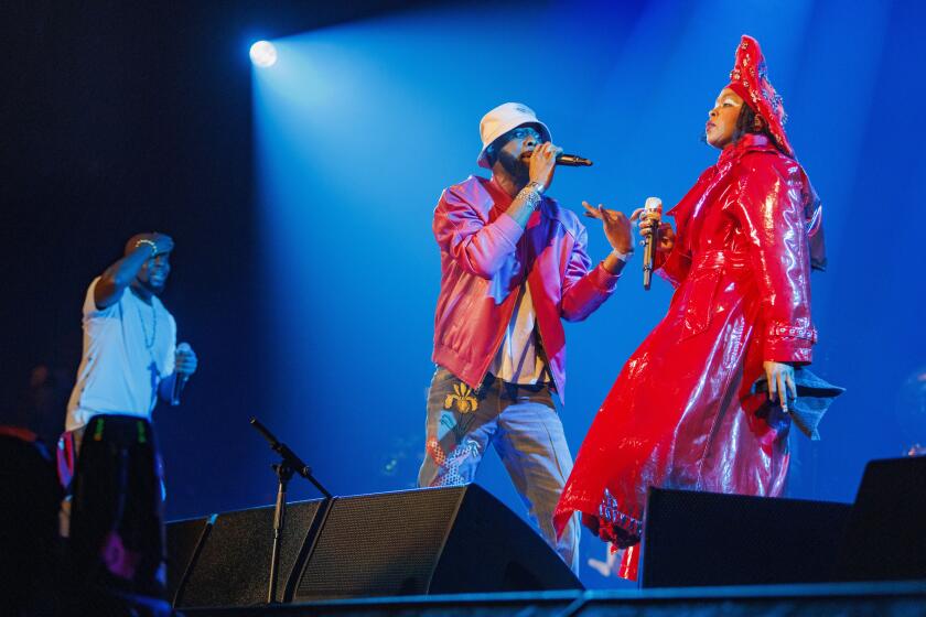 Wyclef Jean, from left, Pras, and Lauryn Hill of the Fugees perform together onstage