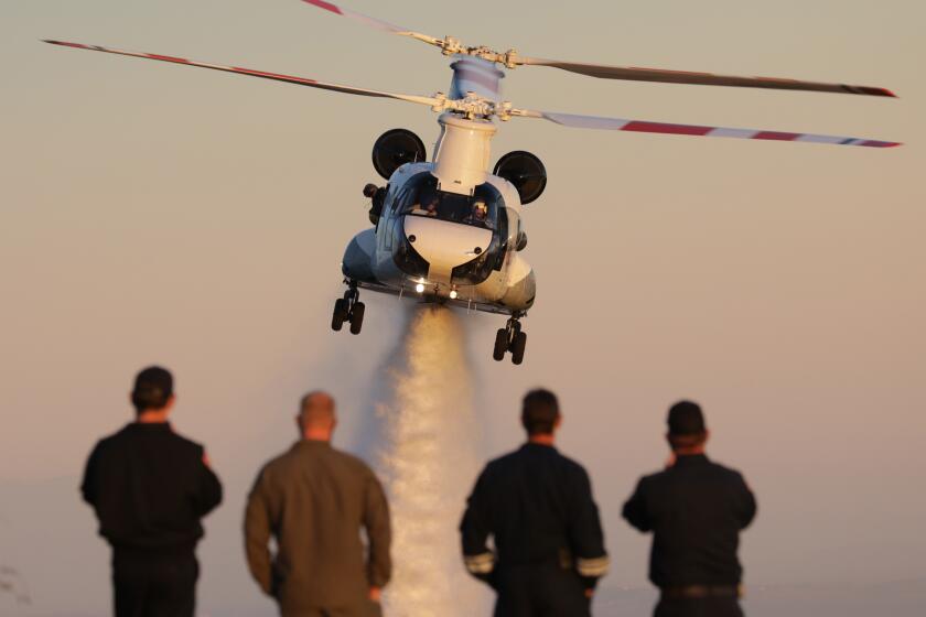 CALABASAS, CA - NOVEMBER 17: A CH-47 Chinook, the world's largest firefighting helicopter and capable of flying at night, can drop 3,000 gallons of water or retardant in a single pass as it demonstrates its capabilities on Tuesday, Nov. 17, 2020 in Calabasas, CA. The helicopter was used in the Silverado fire and dropped 79,000 pounds of fire retardant at night. The helicopter will be available to Los Angeles County and Orange County fire departments. (Myung J. Chun / Los Angeles Times)