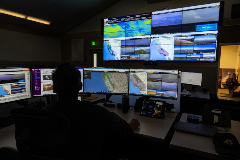 MORENO VALLEY, CA - AUGUST 9, 2023: Cal Fire Scott Slumpff monitors computer screens which depicts views of wildfire camera systems throughout the state of California at the Southern California Geographic Area Coordination Center on August 9, 2023 in Moreno Valley, CA. The agency is using AI to help monitor the camera systems.(Gina Ferazzi / Los Angeles Times)