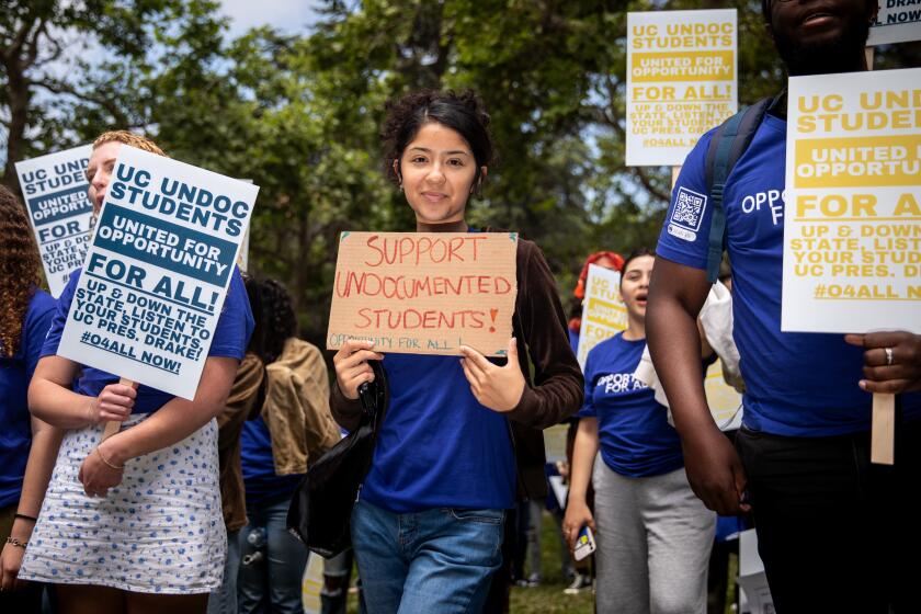 Los Angeles, CA - May 17: Daniela Valadez, a UCLA student majoring in labor studies, holds a sign that reads, "Support undocumented students! Opportunity for all!," as students and supporters gathered to support undocumented students in the University of California system, rallying and marching to protest outside a meeting of the UC Board of Regents meeting, on the UCLA Campus in Los Angeles, CA, Wednesday, May 17, 2023. The rally wants to demand the UC Board of Regents break legal ground and authorize the hiring of students who were brought to this country illegally as children and lack valid work permits. (Jay L. Clendenin / Los Angeles Times)