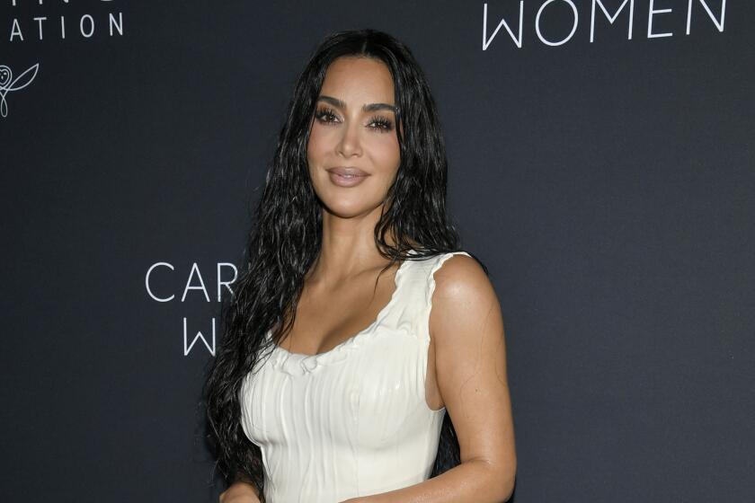 Kim Kardashian smiles in a white gown 